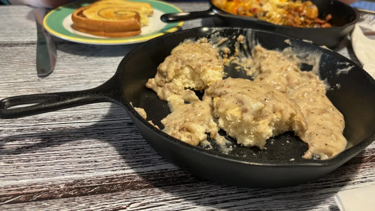Biscuits and gravy in a cast iron skillet on a table